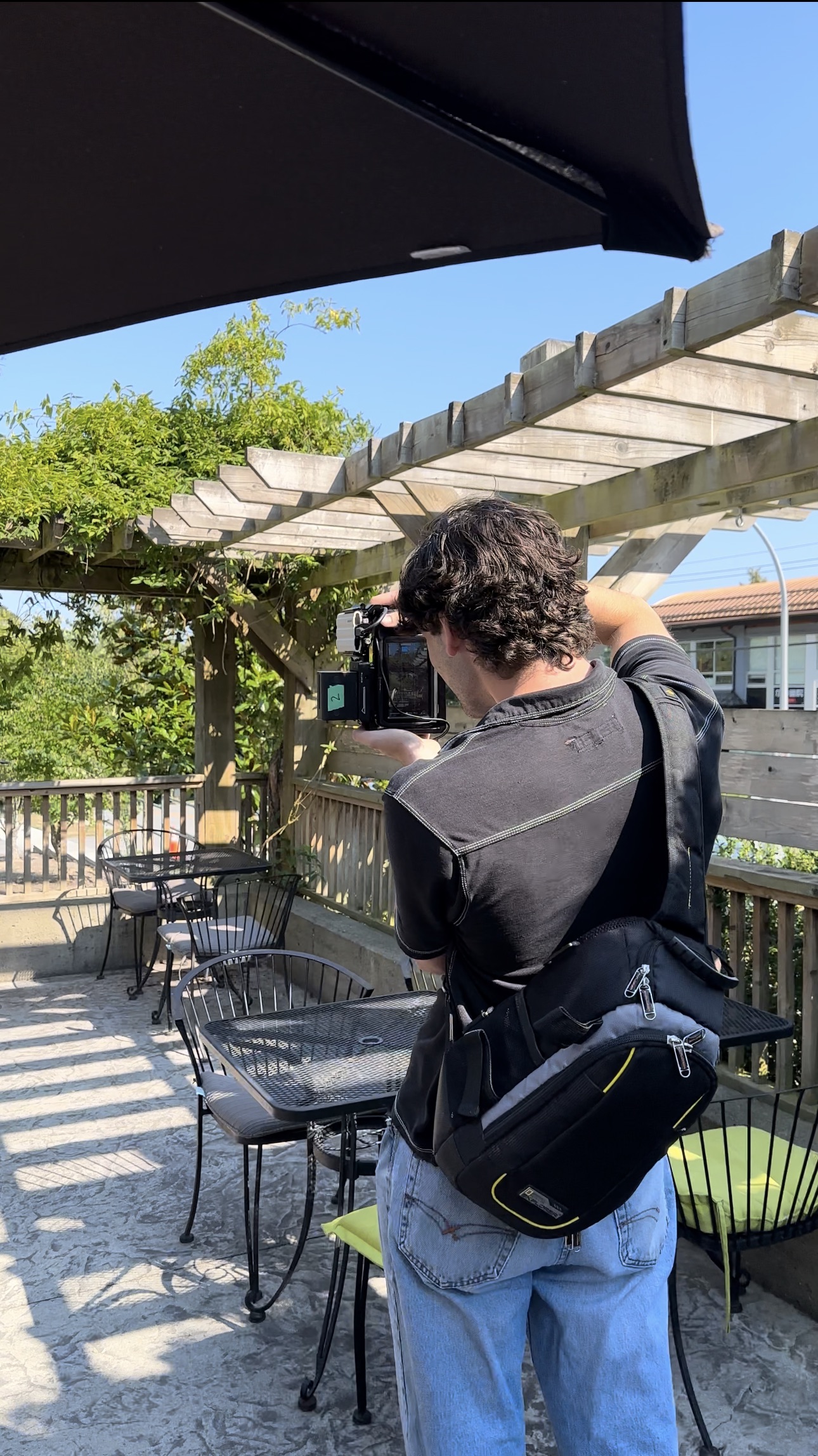 Sam (co-founder of Dinnerparty studio) taking a video outside of a cafe for a client.